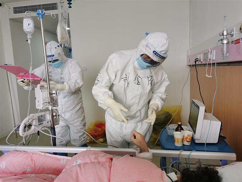 空軍軍醫(yī)大學(xué)西京醫(yī)院心血管外科主任劉金成（右）在湖北省婦幼保健院光谷院區(qū)感染二科病房查看重癥新冠肺炎患者生命體征（3月28日攝）。 新華社發(fā)（杜麗娜 攝）