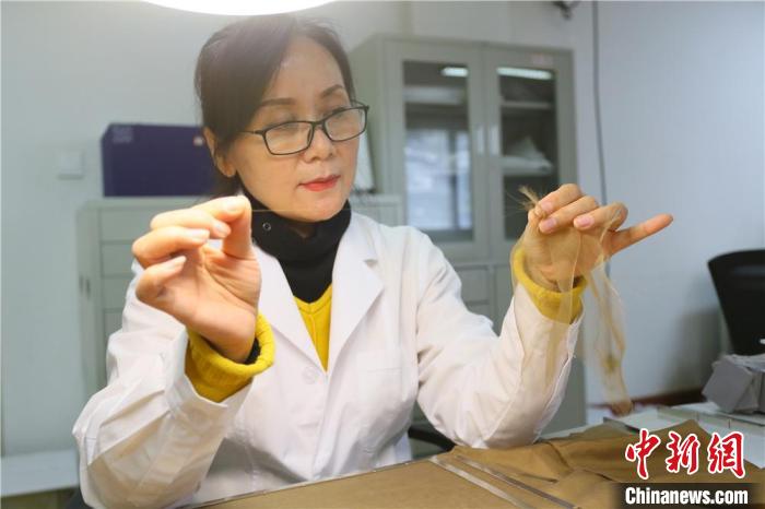 據(jù)趙喜梅介紹，修復(fù)文物紡織品所用的縐絲紗比頭發(fā)絲還細(xì)?！「哒?攝